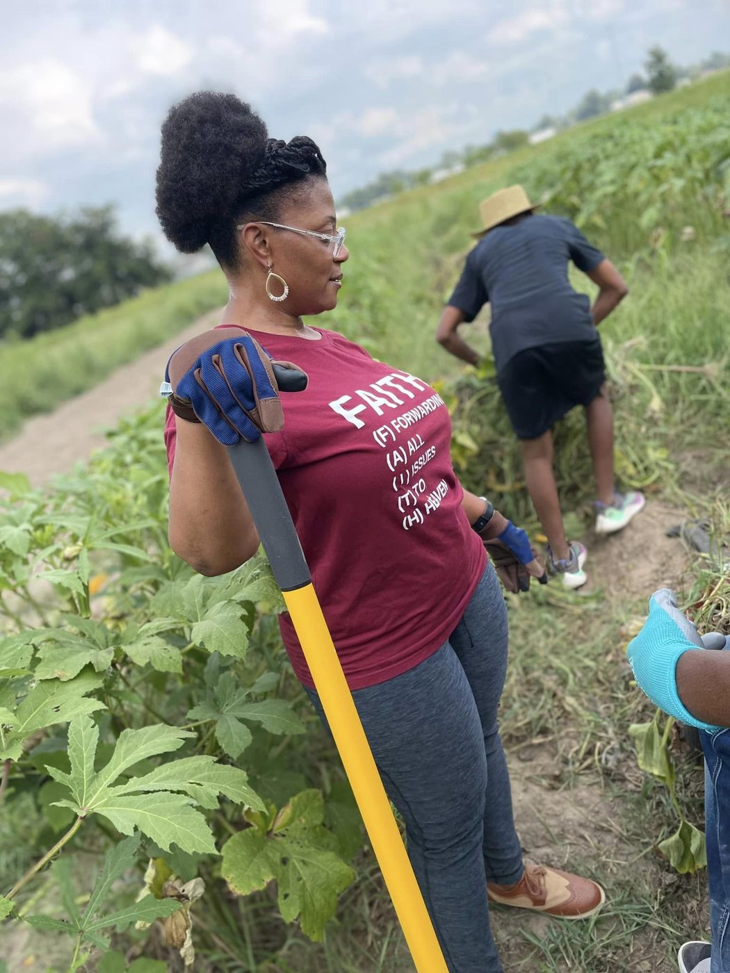 Volunteer in FAITH t-shirt working the okra field