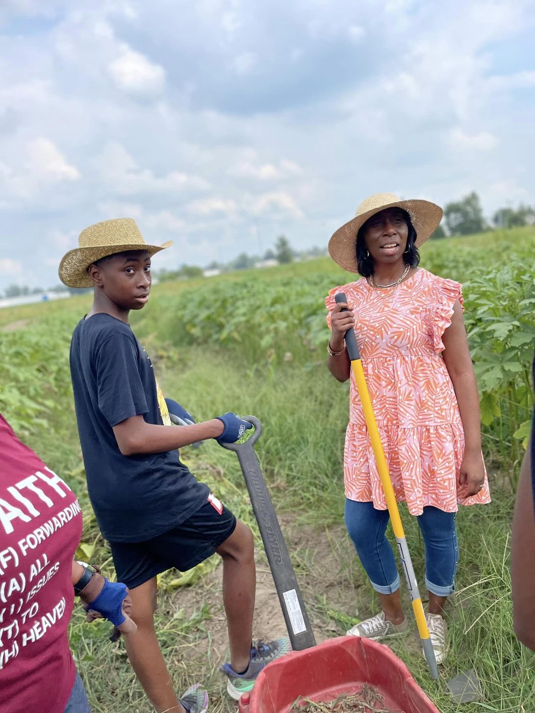 A mentor and young farmer working together in the okra field